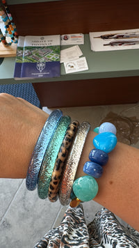 Accumulation de bracelets bleu glacier, turquoise, léopard et champagne, disponible au cerf volant auxerre.