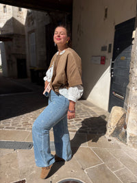 veste femme camel, blouse manches longues en coton écrue, porté avec un jean flare motif coeur pour un look automnal chic et décontracté.