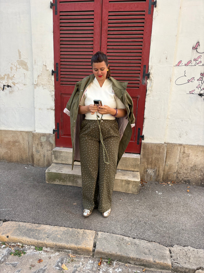 Parka kaki doublée rayée, portée avec une maille crème et un pantalon fleuri kaki, disponibles chez au cerf volant auxerre
