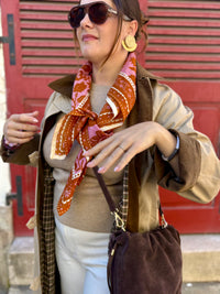 sac seau chocolat, en cuir, porté avec un trench long et un pull camel avec un jean écru, disponibles au cerf volant auxerre
