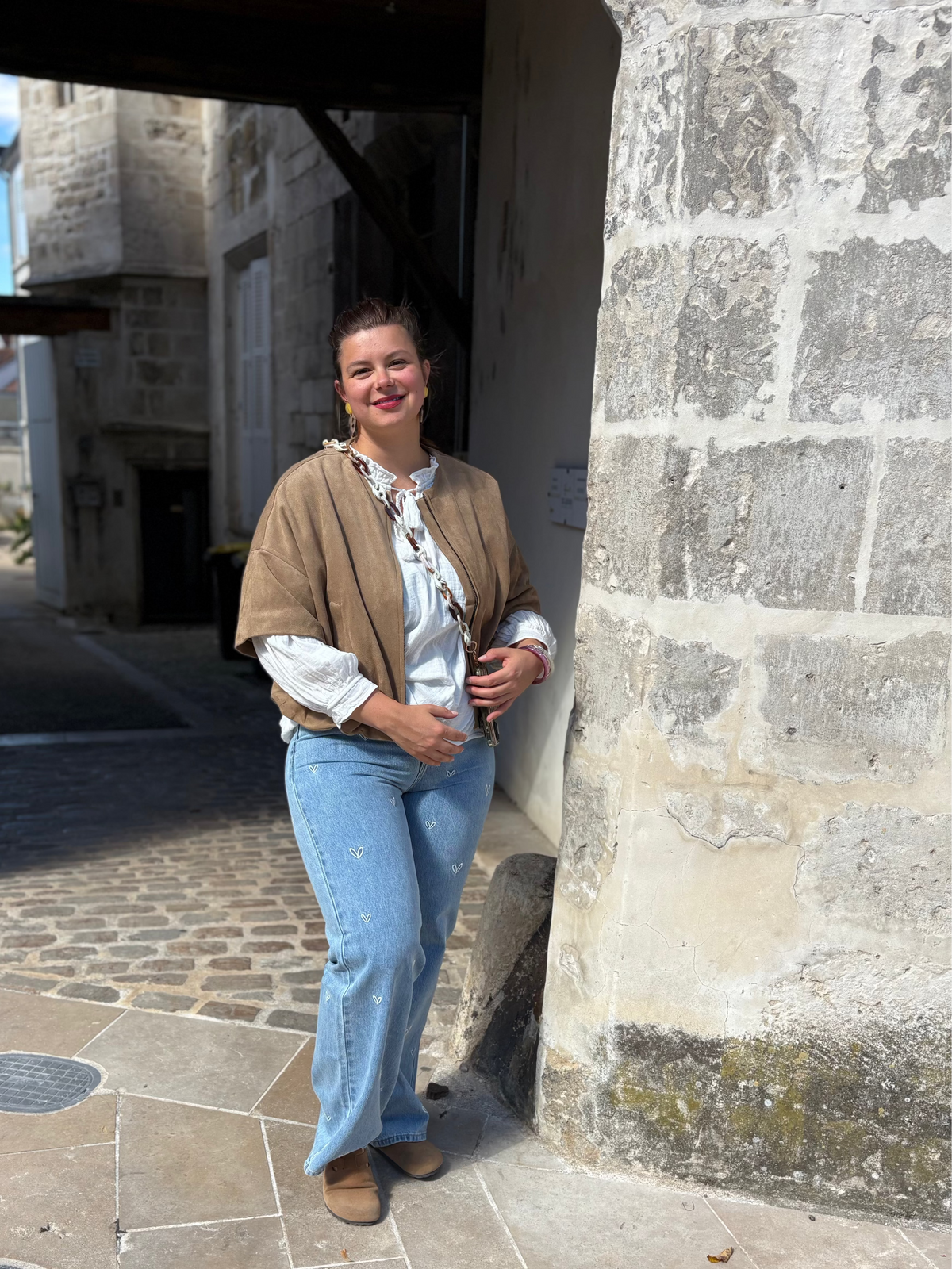 Veste camel, blouse crème et jean flare brodé, disponible au cerf volant auxerre